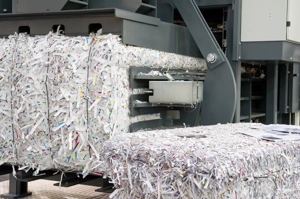 Shredding machine in action, processing and moving shredded confidential documents.