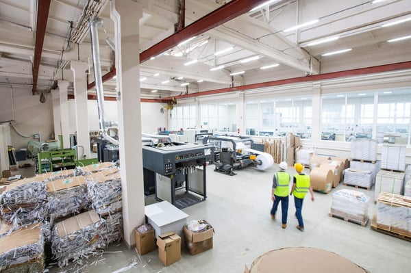 ProShred warehouse with two workers organizing and managing document shredding operations.