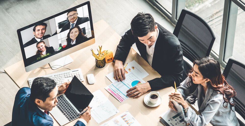 People gathered up in a meeting using a conference call system to connect with international co-workers