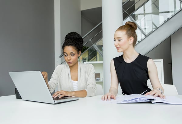 Two girls planning their Google Workspace to Microsoft 365 migration while looking at a computer