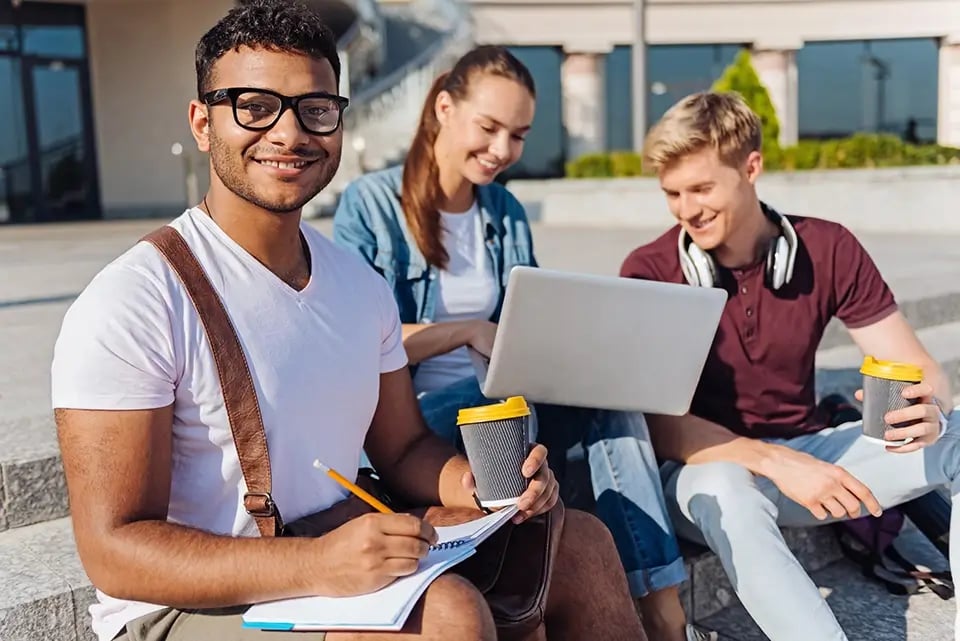 students at a campus working on a laptop